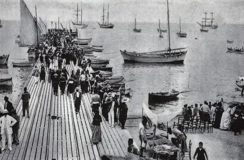 Crowds walking along Limassol's wooden pier in the early 1900s