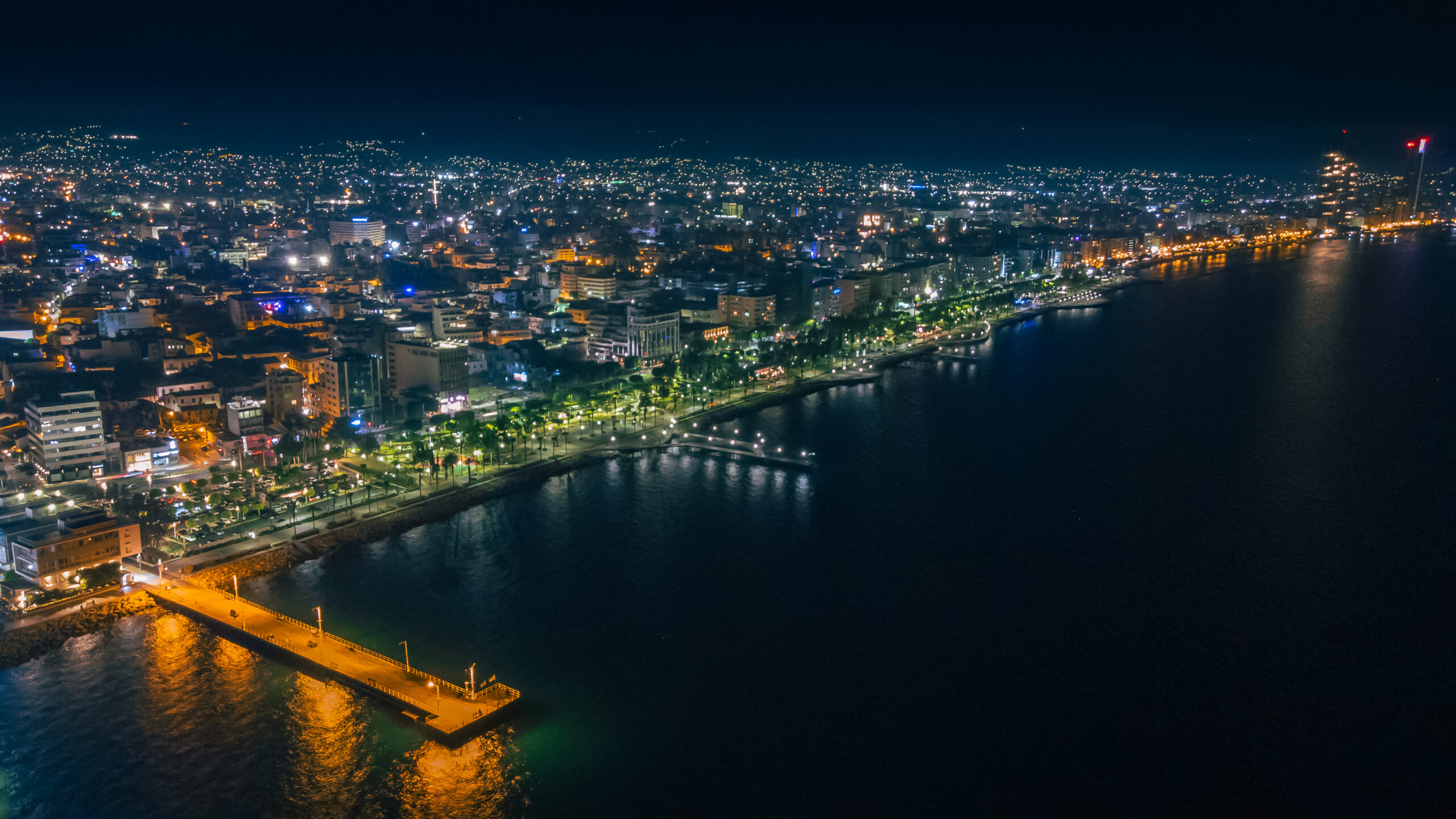 Nighttime cityscape along the Limassol coastline with illuminated buildings